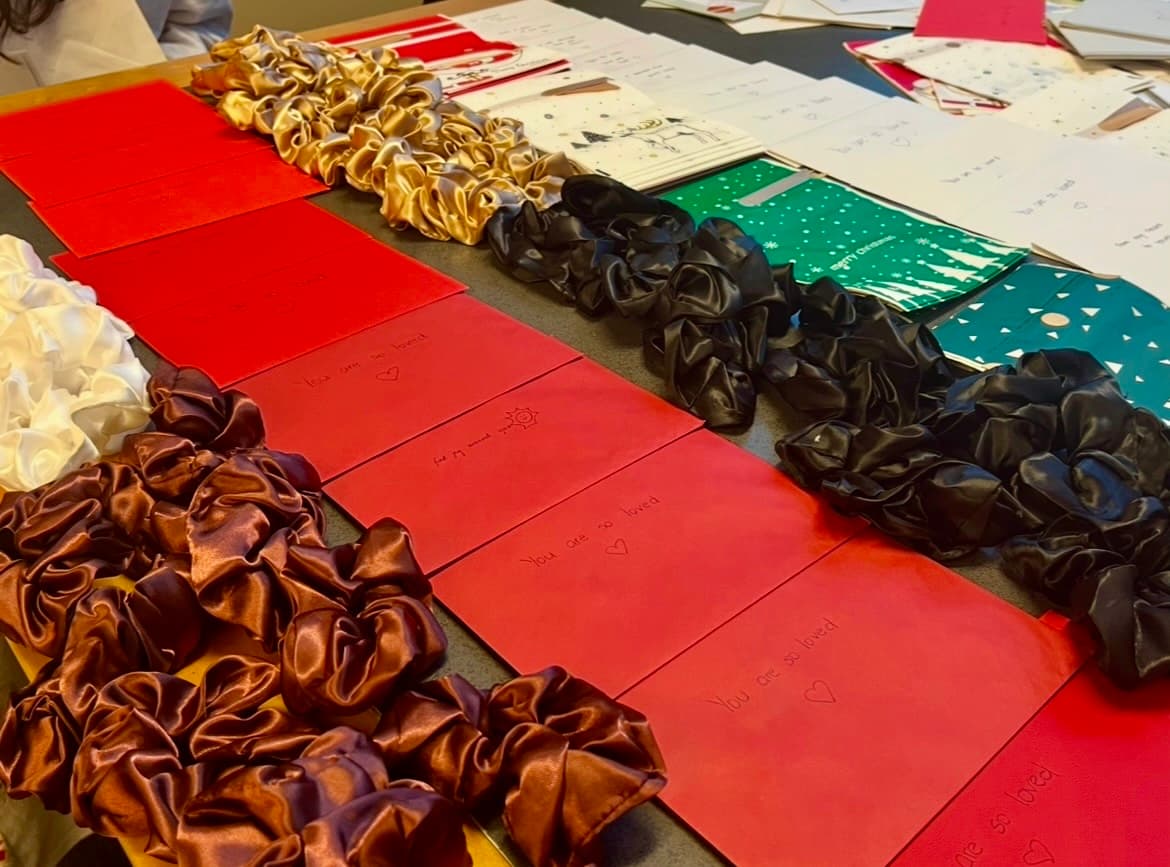 Handwritten notes and scrunchies laid out for care packages