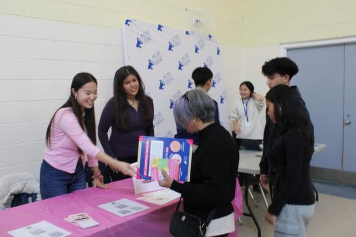 Sunny and the team speaking with visitors at The Pink Stairs table